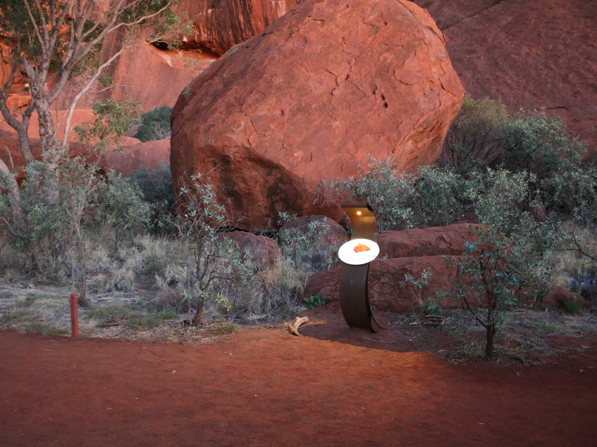 A track maker with a way finding oval map of Uluru. Fixed above the map is a custom designed solar powered LED light, controlled by a micro processor, that turns the light on automatically at dusk for two hours only and then two hours prior to sunrise.
